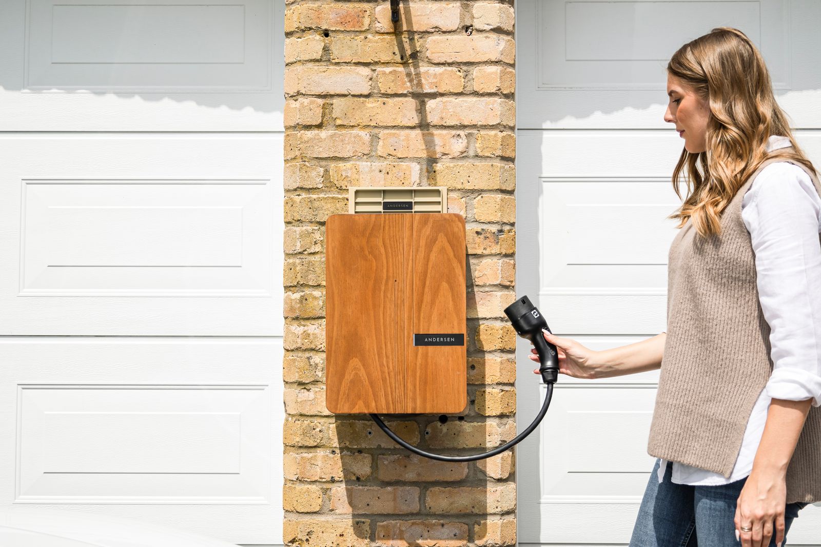 An electric vehicle plugged into a wall-mounted home charging unit.