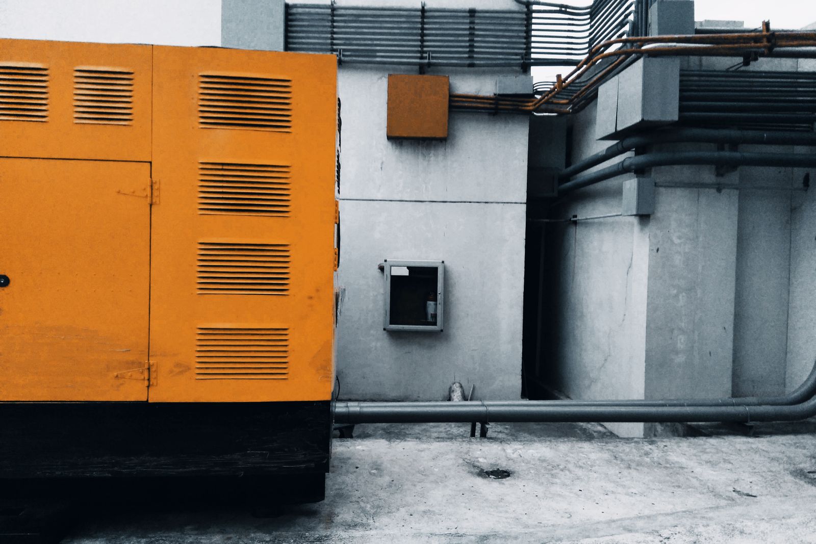 Standby generator equipment installed on a pad beside a property.