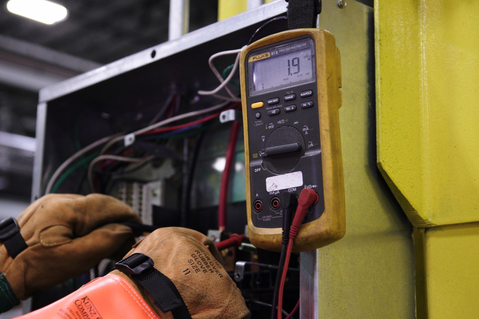 A multimeter probe held against a circuit terminal while a fault is traced.