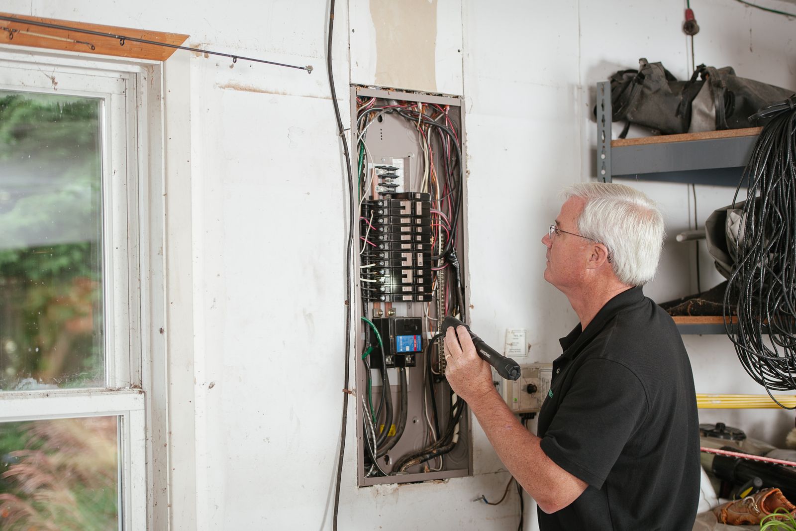 An electrician mounting equipment inside an electrical panel enclosure.